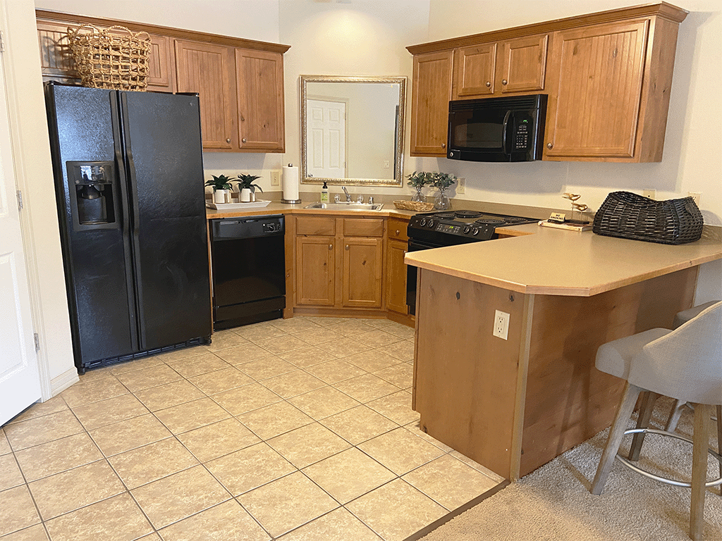 A kitchen with black appliances and wooden cabinets.